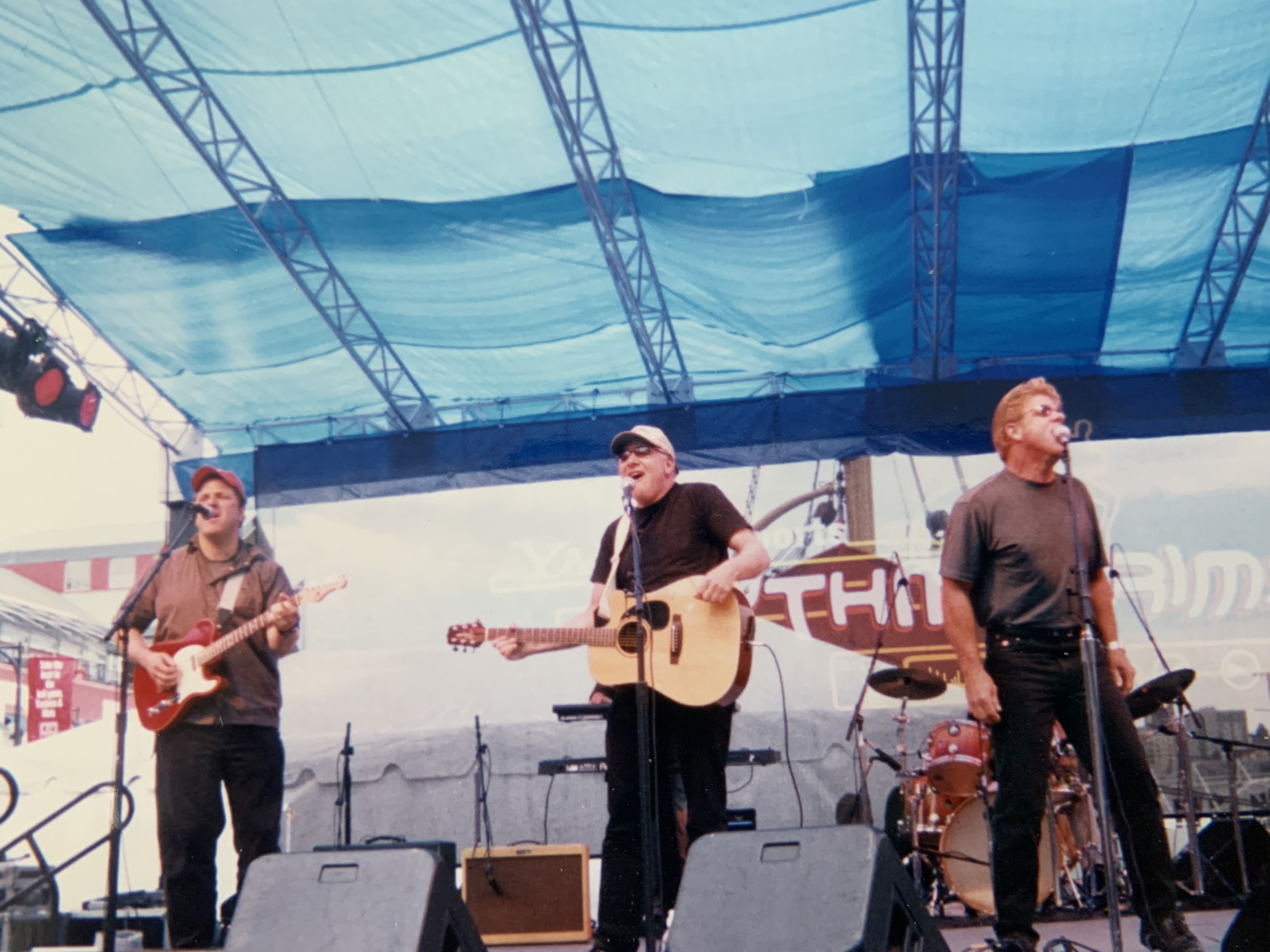 Loaded performing on a festival stage under a blue canopy